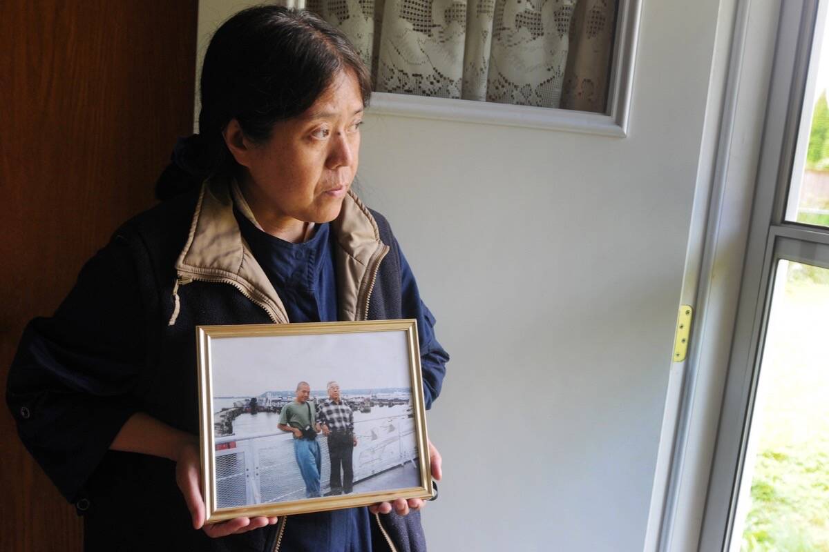 In 2019 Yin Yin Din holds a picture of her brother Kyaw Naing Din, 54, and her late father Hla Din who passed away in 2014, on a trip to Victoria when Kyaw was only 34-years-old. (Colleen Flanagan/THE NEWS)