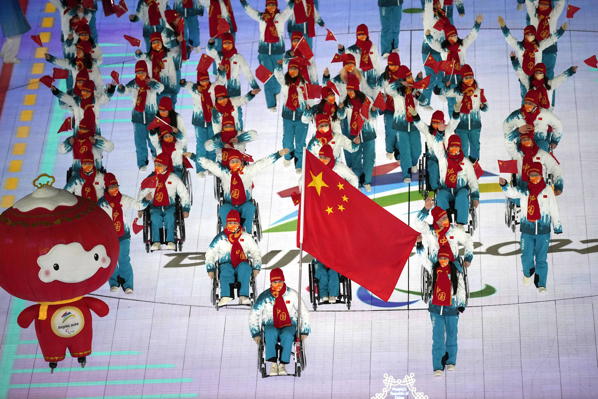 Guo Yujie and Wang Zhidong carry the flag of China as they make their entrance during the opening ceremony at the 2022 Winter Paralympics, Friday, March 4, 2022, in Beijing. (AP Photo/Dita Alangkara)