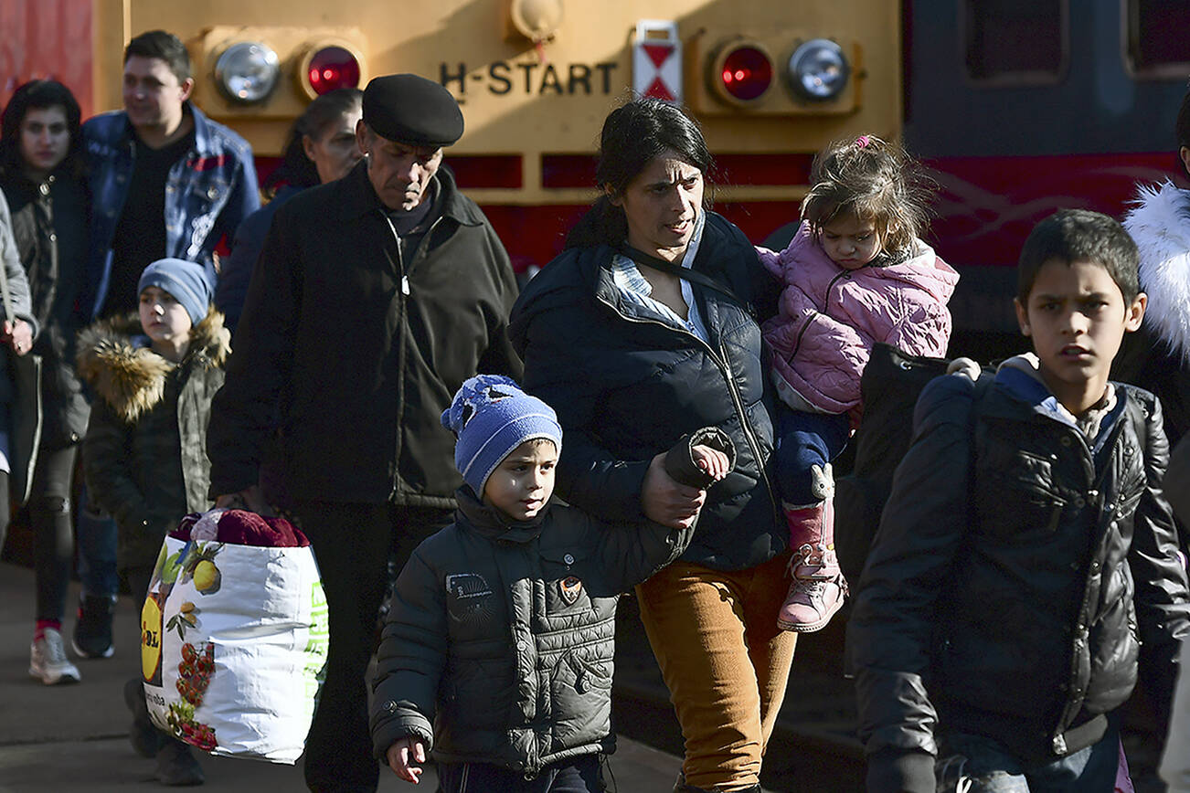 Refugees fleeing conflict from neighboring Ukraine arrive to Zahony, Hungary, Sunday, Feb. 27, 2022. As hundreds of thousands of Ukrainians seek refuge in neighboring countries, cradling children in one arm and clutching belongings in the other. (AP Photo/Anna Szilagyi, File photo)