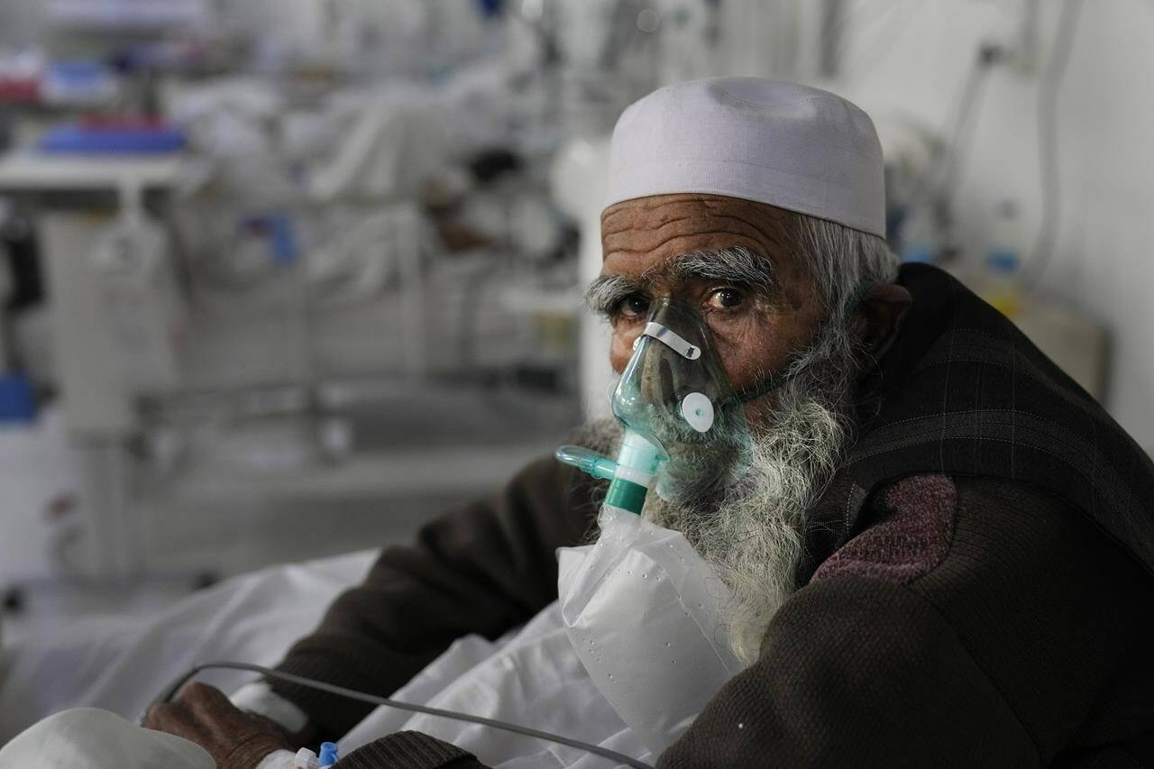 FILE - A patient infected with the coronavirus sits on a bed in the intensive care unit of the Afghan Japan Communicable Disease Hospital, in Kabul, Afghanistan, Monday, Feb. 7, 2022. The official global death toll from COVID-19 is on the verge of eclipsing 6 million — underscoring that the pandemic, now in its third year, is far from over. (AP Photo/Hussein Malla, File)