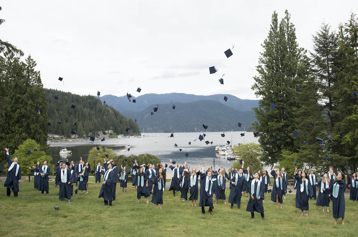 Graduating students from Seycove Secondary in Deep Cove, North Vancouver, B.C. throw their hats during a physically distanced graduation photo Wednesday, June 3, 2020. Graduating students all over the world are celebrating their grads in different ways due to the COVID-19 pandemic. THE CANADIAN PRESS/Jonathan Hayward