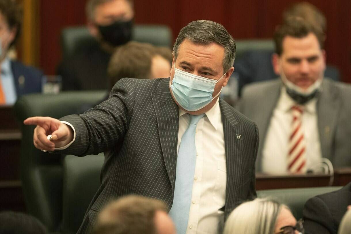 Alberta Premier Jason Kenney points to people in the chamber before the speech from the throne is delivered in Edmonton on Tuesday, Feb. 22, 2022. THE CANADIAN PRESS/Jason Franson