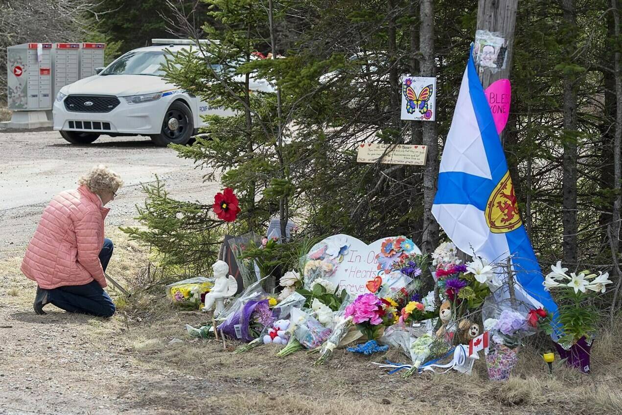 A woman pays her respects at a roadblock in Portapique, N.S. on Wednesday, April 22, 2020. THE CANADIAN PRESS/Andrew Vaughan