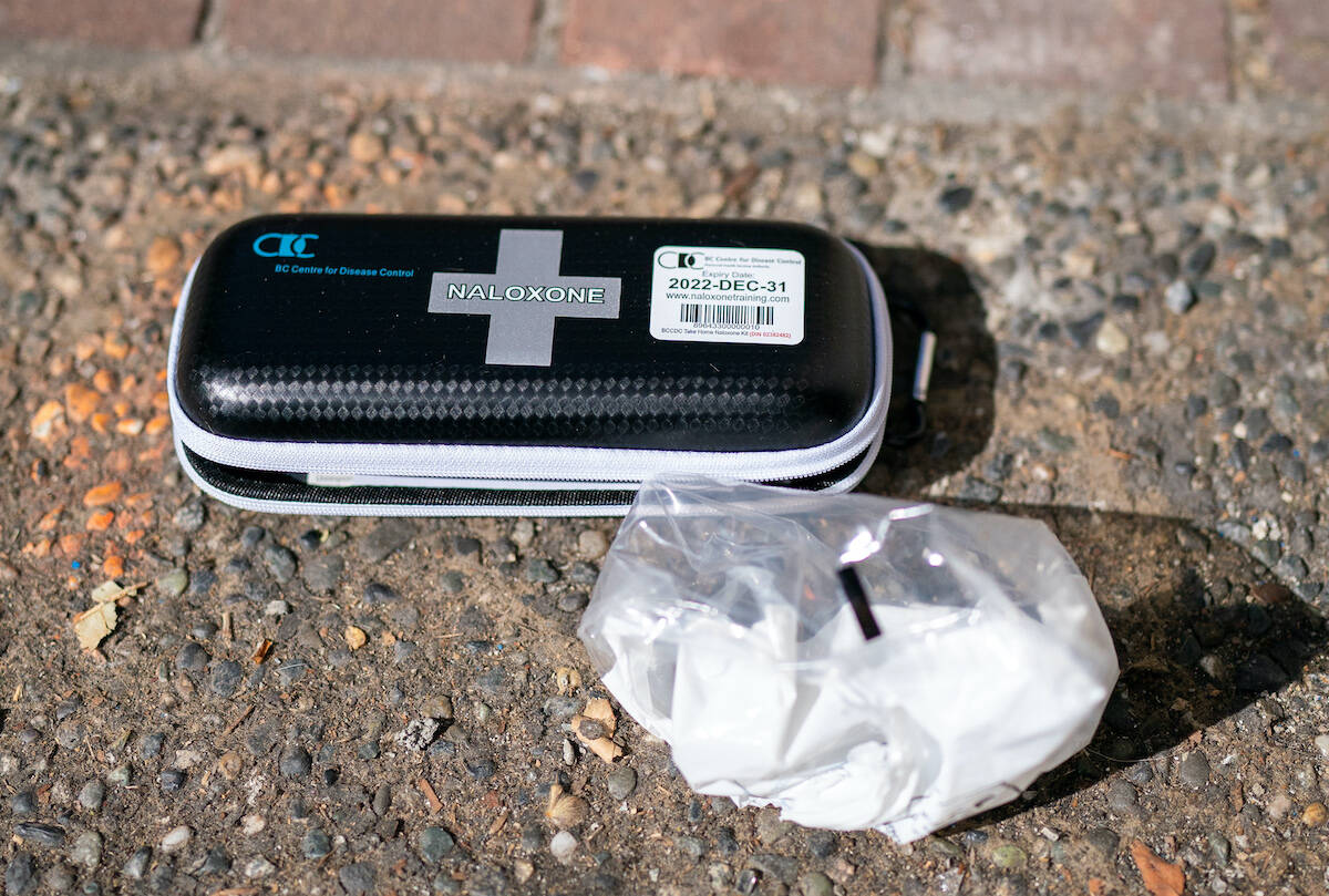 A used naloxone kit is seen on the sidewalk as paramedics from B.C. Ambulance respond to a drug overdose in downtown Vancouver, Wednesday, June 23, 2021. (THE CANADIAN PRESS/Jonathan Hayward)