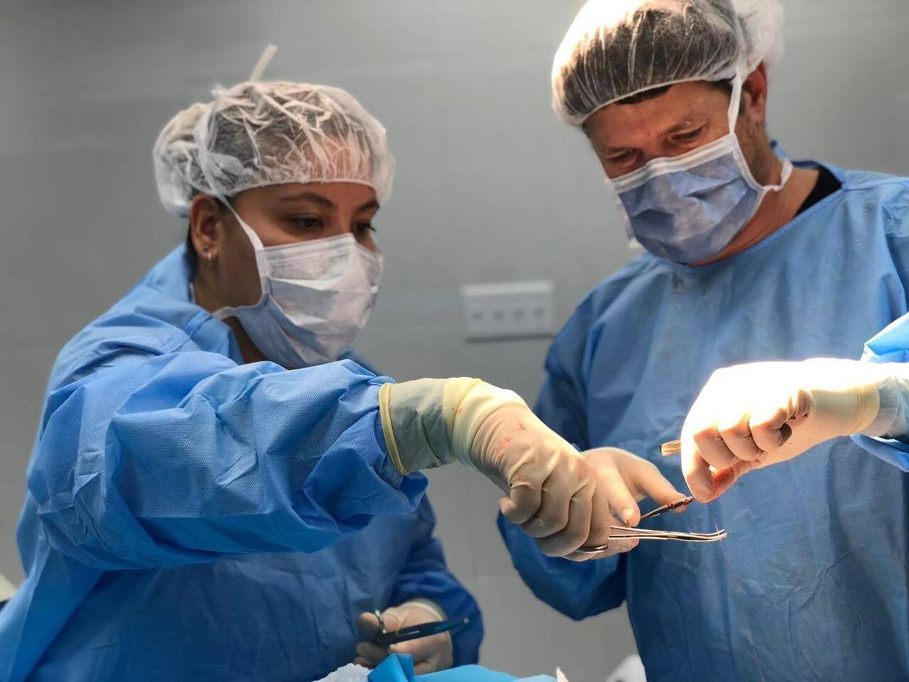 Physician assistant Joanna Chan, left, assists plastic surgeon Dr. Michel Gallant, right, with the placement of a skin graft to a child’s head during an operation in Port-au-Prince, Haiti, in a 2018 handout photo. Chan was part of a medical team with the organization Team Broken Earth. THE CANADIAN PRESS/HO-Team Broken Earth