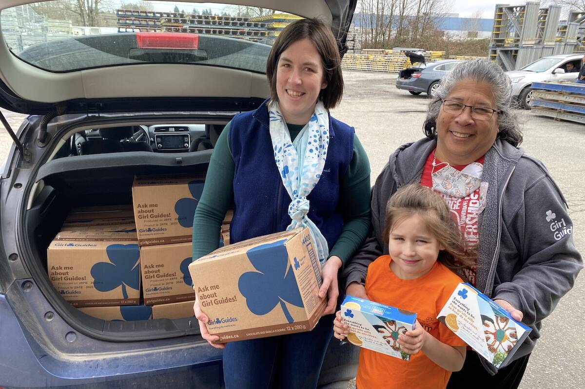 Sarah Beairsto (left), seven-year-old Harper Harvey and Debra Legge with boxes of Girl Guides cookies outside a warehouse in North Delta on Saturday, March 12. (Photo: Tom Zillich)