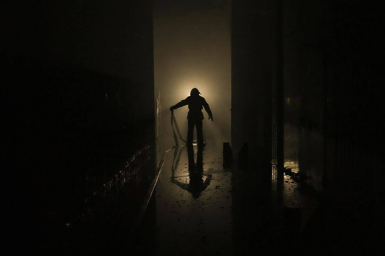 A Ukrainian firefighter drags a hose inside a large food products storage facility which was destroyed by an airstrike in the early morning hours in Brovary, north of Kyiv, Ukraine, Sunday, March 13, 2022. Waves of Russian missiles pounded a military training base close to Ukraine’s western border with NATO member Poland, killing 35 people, following Russian threats to target foreign weapon shipments that are helping Ukrainian fighters defend their country against Russia’s grinding invasion.(AP Photo/Vadim Ghirda)
