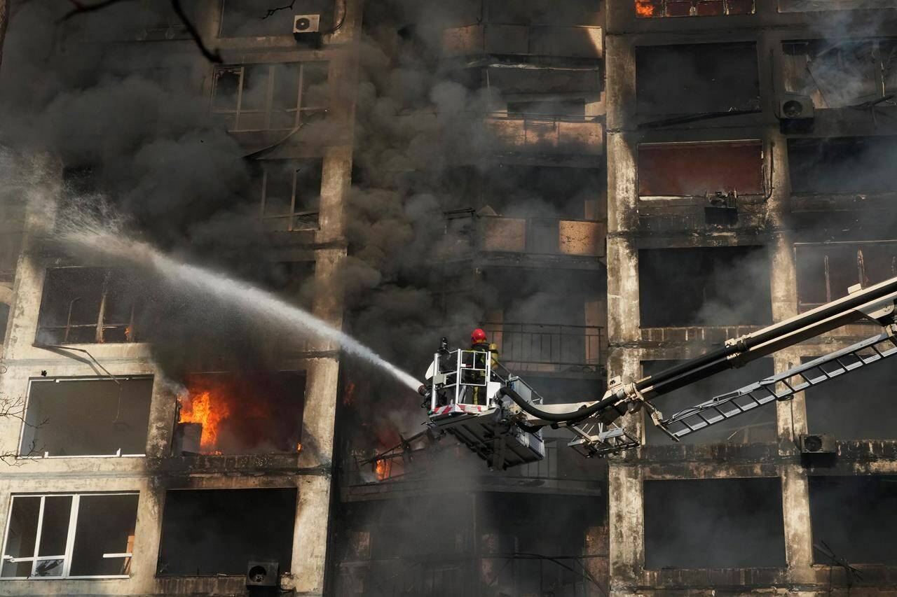 Firefighters work in an apartment building damaged by shelling in Kyiv, Ukraine, Tuesday, March 15, 2022. (AP Photo/Efrem Lukatsky)