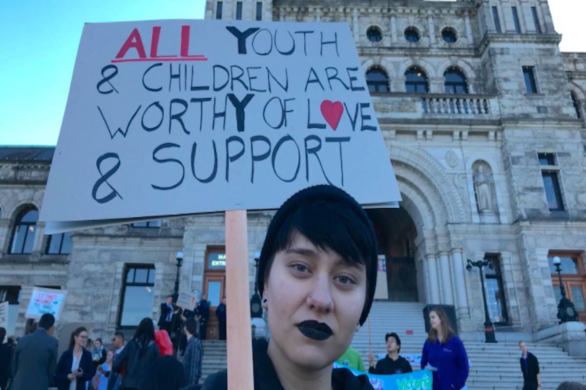 Advocates have long called for changes to better support youth in care. This 2018 file photo shows a protester on the steps of the B.C. Legislature calling for improved supports. (Arnold Lim/Black Press)