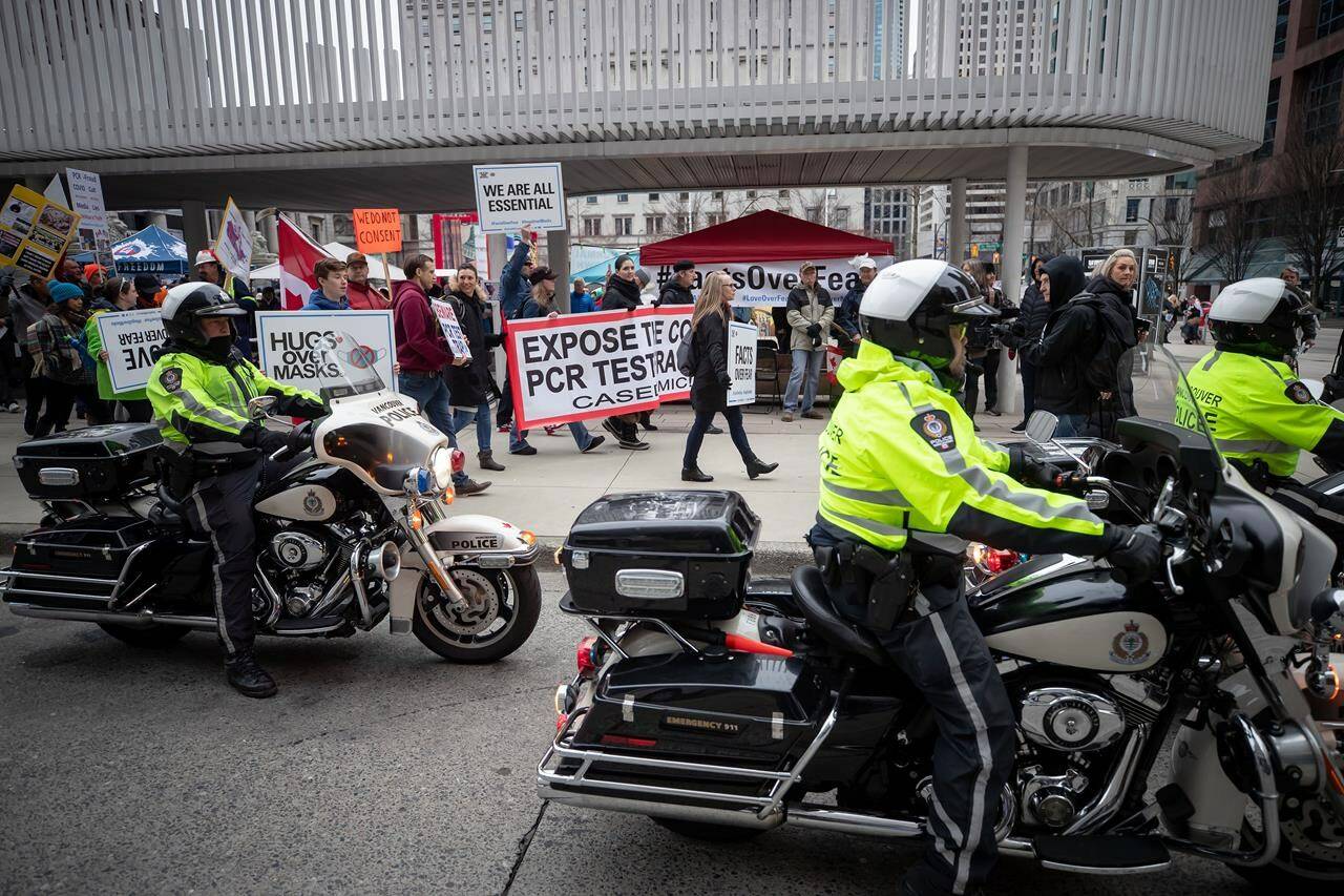 The Vancouver Police Board has successfully appealed a City of Vancouver decision that cut millions from the 2021 police budget, and the timing means the pinch of the ruling won’t hit taxpayers until next year. People opposed to public health measures to curb the spread of COVID-19 are given a police escort as they march after the B.C. Grand Freedom Rally, in Vancouver, on Saturday, February 20, 2021. THE CANADIAN PRESS/Darryl Dyck