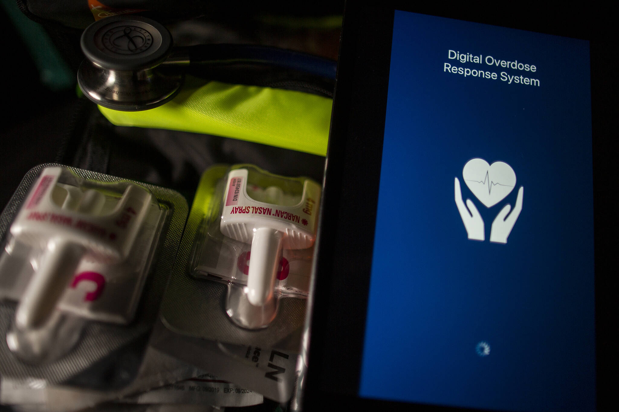 A handheld device showing the loading screen for the Alberta Digital Overdose Response System mobile application is shown alongside a pair of Narcan nasal injectors in a photo illustration in Toronto, Monday, Dec. 6, 2021. THE CANADIAN PRESS/Giordano Ciampini