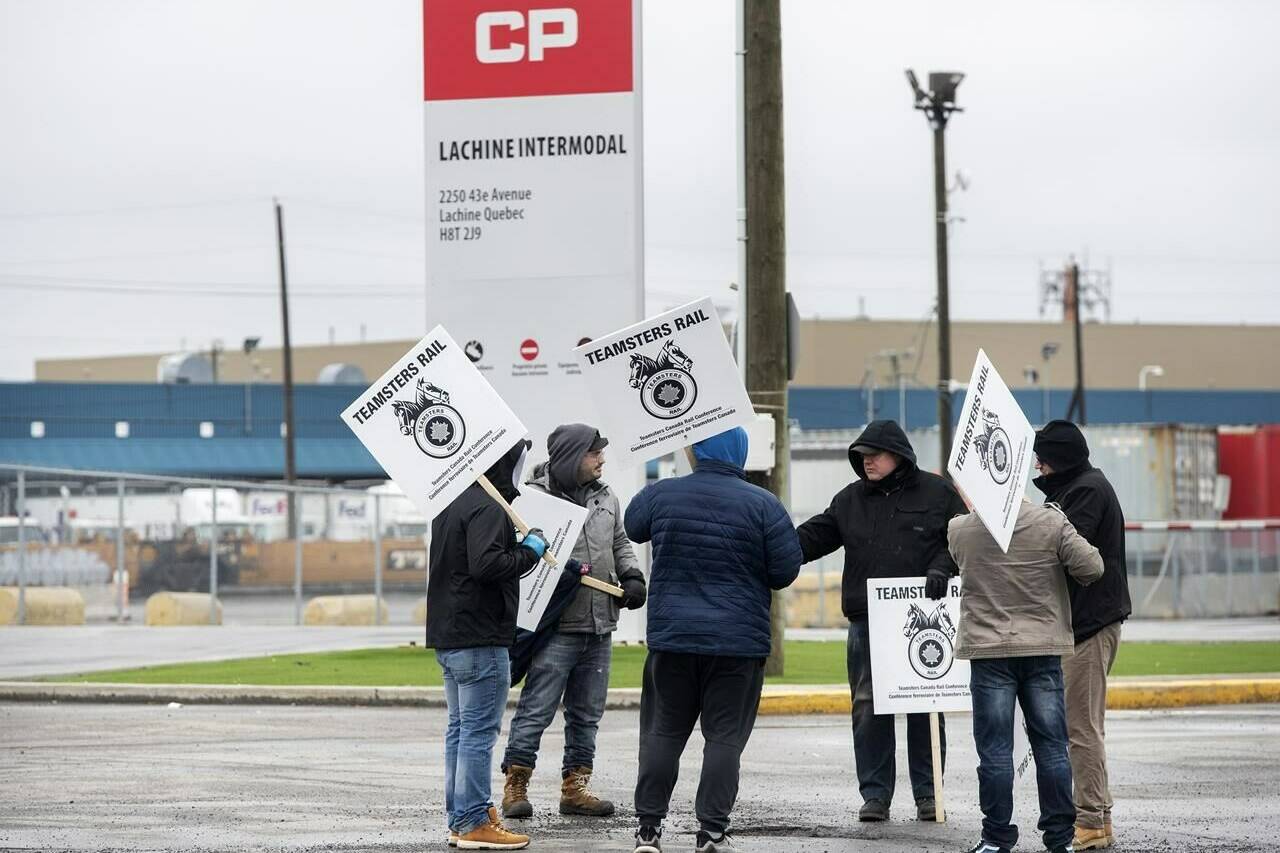 Locked-out CP Rail workers protest outside the Lachine Intermodal facility in Montreal, Sunday, March 20, 2022. The pressure is on in Ottawa today as a CP Rail work stoppage enters its second day. THE CANADIAN PRESS/Graham Hughes