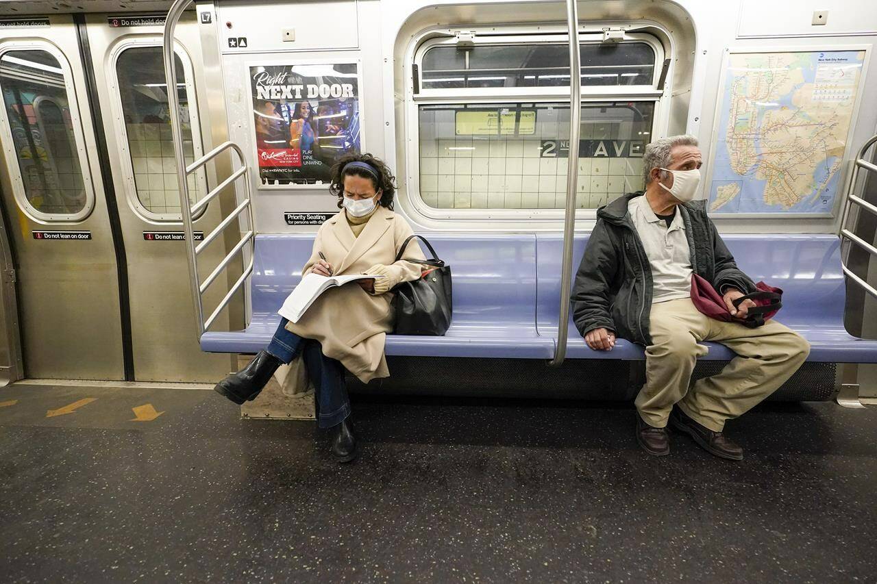FILE - Commuters wear face masks and social distance. (AP Photo/Mary Altaffer, File)