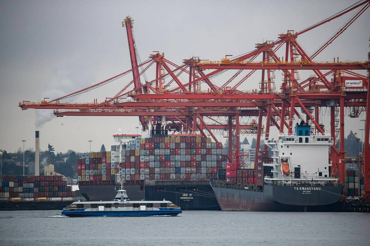 A SeaBus travels across Burrard Inlet as gantry cranes tower above container ships being unloaded and loaded at port, in Vancouver, on Thursday, February 10, 2022. The Vancouver Fraser Port Authority says cargo volumes increased one per cent to 146 million tonnes last year despite the pandemic, global supply chain challenges and extreme weather in B.C. at the end of the year. THE CANADIAN PRESS/Darryl Dyck