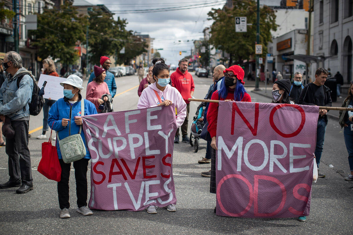 People hold banners during a march to remember those who died during the overdose crisis and to call for a safe supply of illicit drugs on International Overdose Awareness Day, in Vancouver, on Tuesday, August 31, 2021. British Columbia’s chief coroner says at least 1,011 people died from suspected illicit drug overdoses from January to June, the highest death toll recorded in the first six months of a calendar year during the province’s overdose crisis. THE CANADIAN PRESS/Darryl Dyck