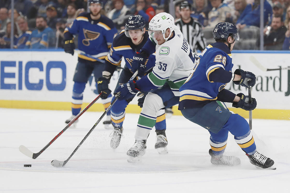 Vancouver Canucks centre Bo Horvat (53) works the puck during the second period of an NHL hockey game against the St. Louis Blues on Monday, March 28, 2022, in St. Louis. (AP Photo/Michael Thomas)