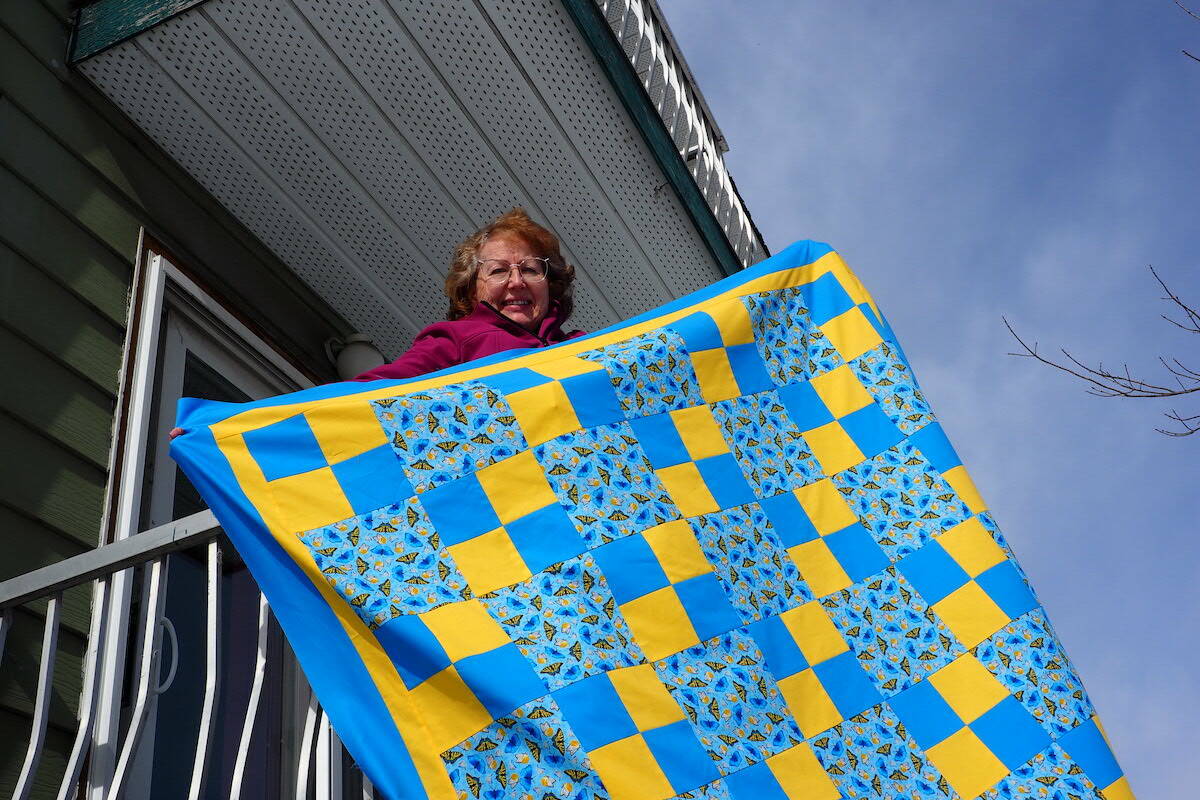 Lily Bowers with her Ukraine flag-style quilt, made to help raise funds to support those displaced by the conflict in Ukraine. (Scott Tibballs / The Free Press)