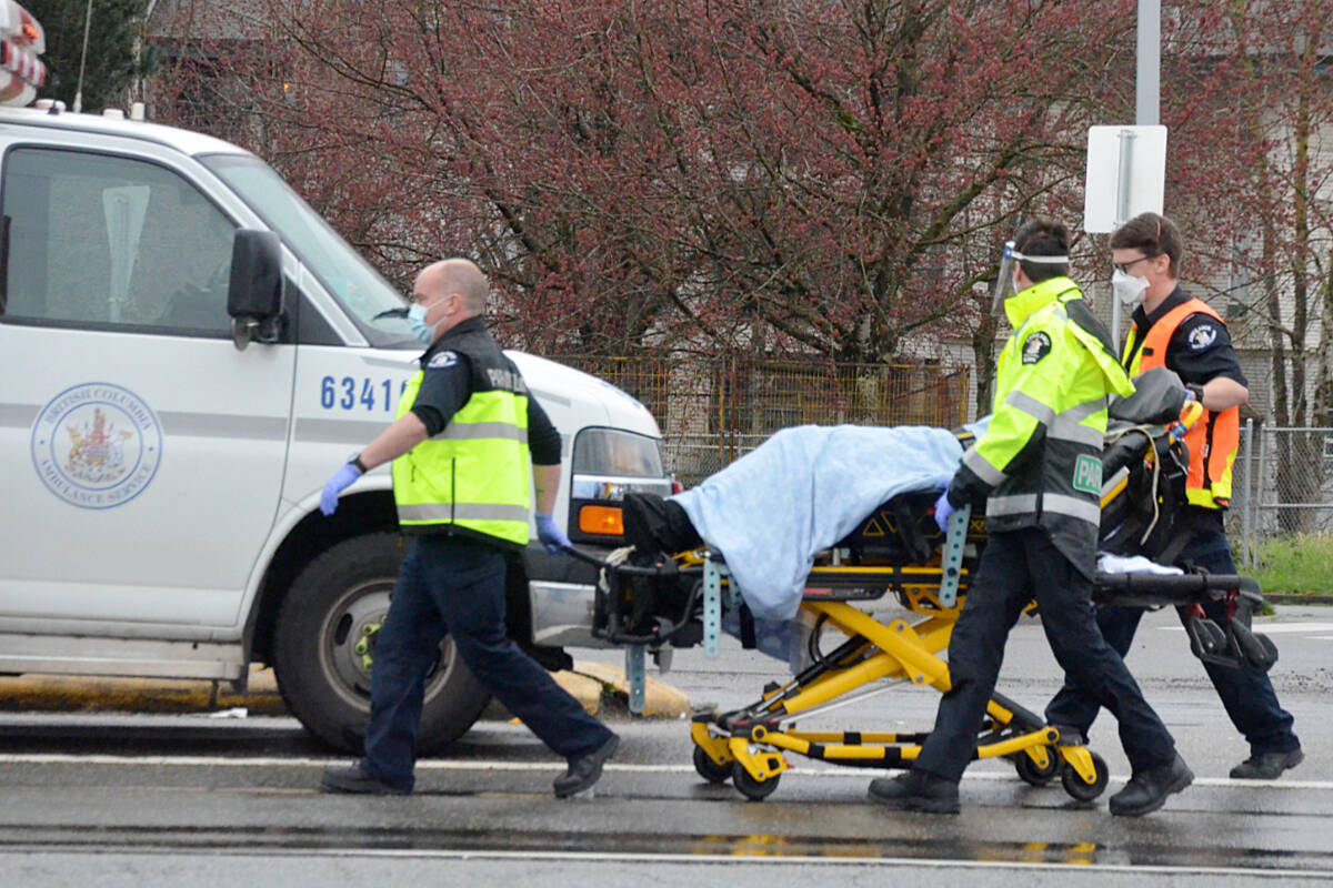 BC Ambulance paramedics and Surrey RCMP took away a man who was found running through traffic around Fraser Highway on Monday, March 28, near the Surrey-Langley border. (Matthew Claxton/Langley Advance Times)