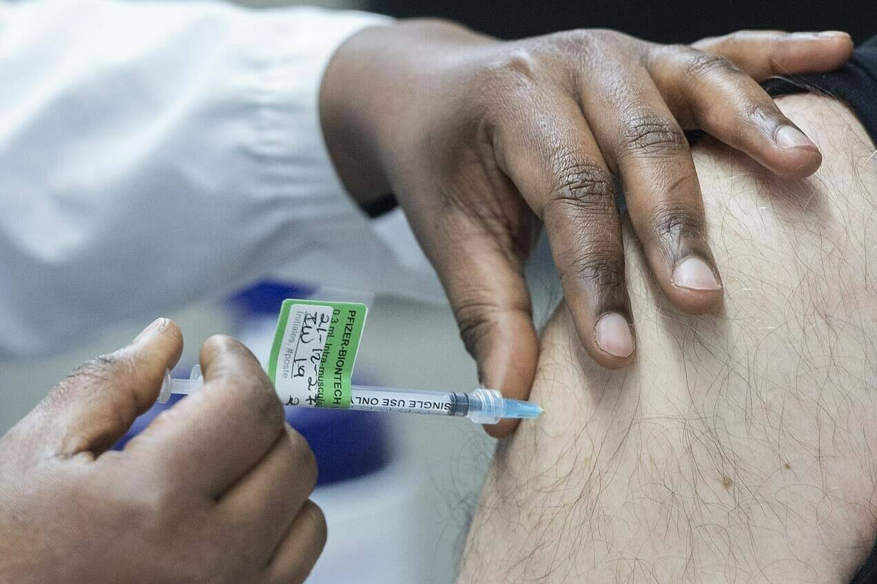 A man receives a Pfizer-BioNTech COVID-19 booster vaccine dose at the Olympic Stadium in Montreal on Dec. 27, 2021. The National Advisory Committee on Immunization is expected to soon release guidance on fourth doses of COVID-19 vaccine as public health indicators tick up across Canada. THE CANADIAN PRESS/Graham Hughes