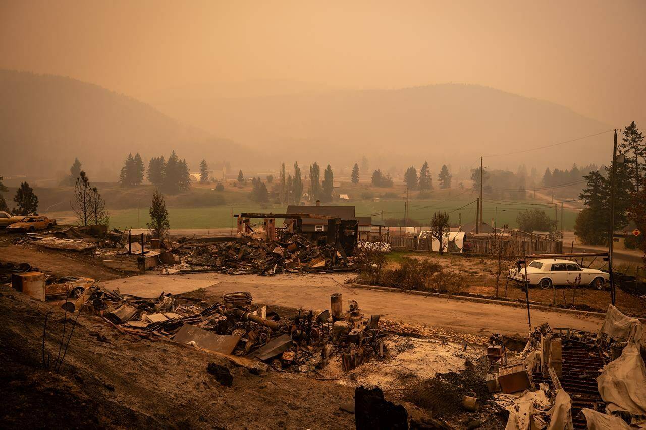 Thick smoke fills the air and nearly blocks out the sun as a property destroyed by the White Rock Lake wildfire is seen in Monte Lake, east of Kamloops, B.C., on Saturday, August 14, 2021. An alert system is being installed on a slope scorched by fire in British Columbia’s Interior, allowing for an early warning to the homes below if the deforested hillside gives way in heavy rain. THE CANADIAN PRESS/Darryl Dyck