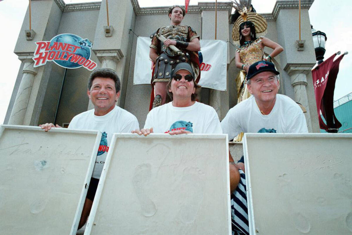 Former teen idols from the ’50s and ’60s Frankie Avalon, left, Fabian, centre, and Bobby Rydell, right, show off their foot prints in plaster casts Friday, July 3, 1998, on the Boardwalk in Atlantic City, N.J. Rydell, a pompadoured heartthrob of early rock ‘n roll who was a star of radio, television and the movie musical “Bye Bye Birdie,” died Tuesday, April 5, 2022. He was 79. Along with James Darren, Fabian and Frankie Avalon, Rydell was among a wave of wholesome teen idols who emerged after Elvis Presley and before the rise of the Beatles. (AP Photo/B. Vartan Boyajian, File)