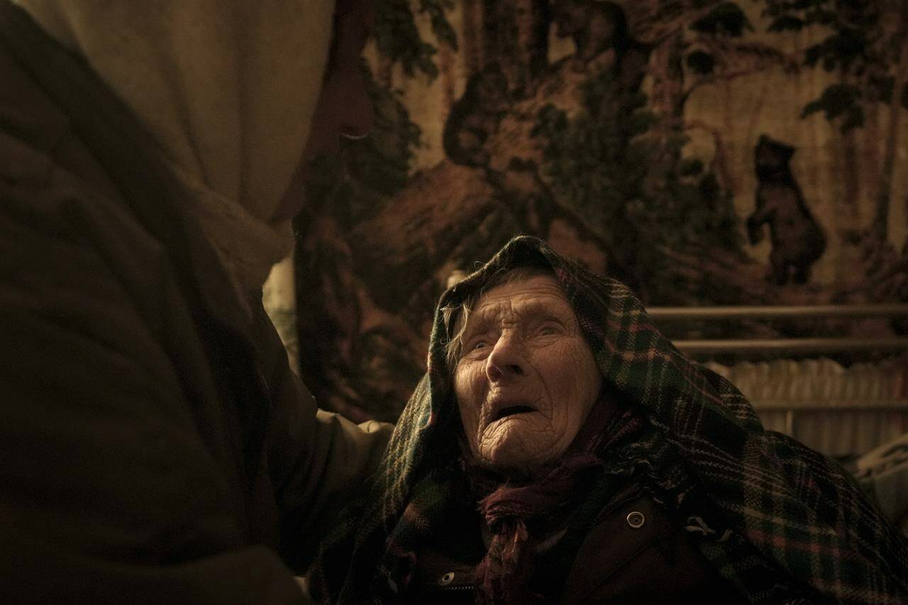 Motria Oleksiienko, 99 years-old, traumatized by the Russian occupation, is comforted by daughter-in-law Tetiana Oleksiienko in a room without heating in the village of Andriivka, Ukraine, heavily affected by fighting between Russian and Ukrainian forces, Wednesday, April 6, 2022. Several buildingsa in the village were reduced to mounds of bricks and corrugated metal and residents struggle without heat, electricity or cooking gas. (AP Photo/Vadim Ghirda)