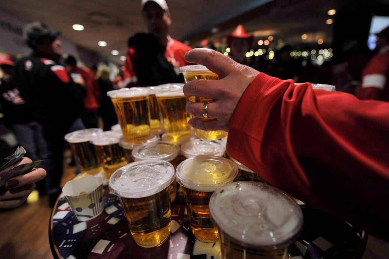 Hockey fans load up on beer at a bar in Edmonton on Dec. 31, 2011. The southern Alberta town of Raymond — dry since it was founded more than 100 years ago — is asking residents if they are for or against restaurants serving alcohol. THE CANADIAN PRESS/Nathan Denette