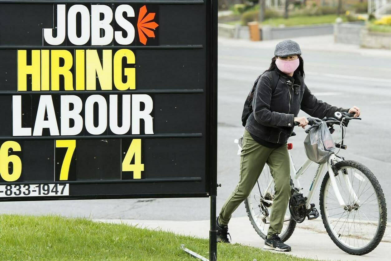 A woman checks out a jobs advertisement sign in Toronto on Wednesday, April 29, 2020. THE CANADIAN PRESS/Nathan Denette