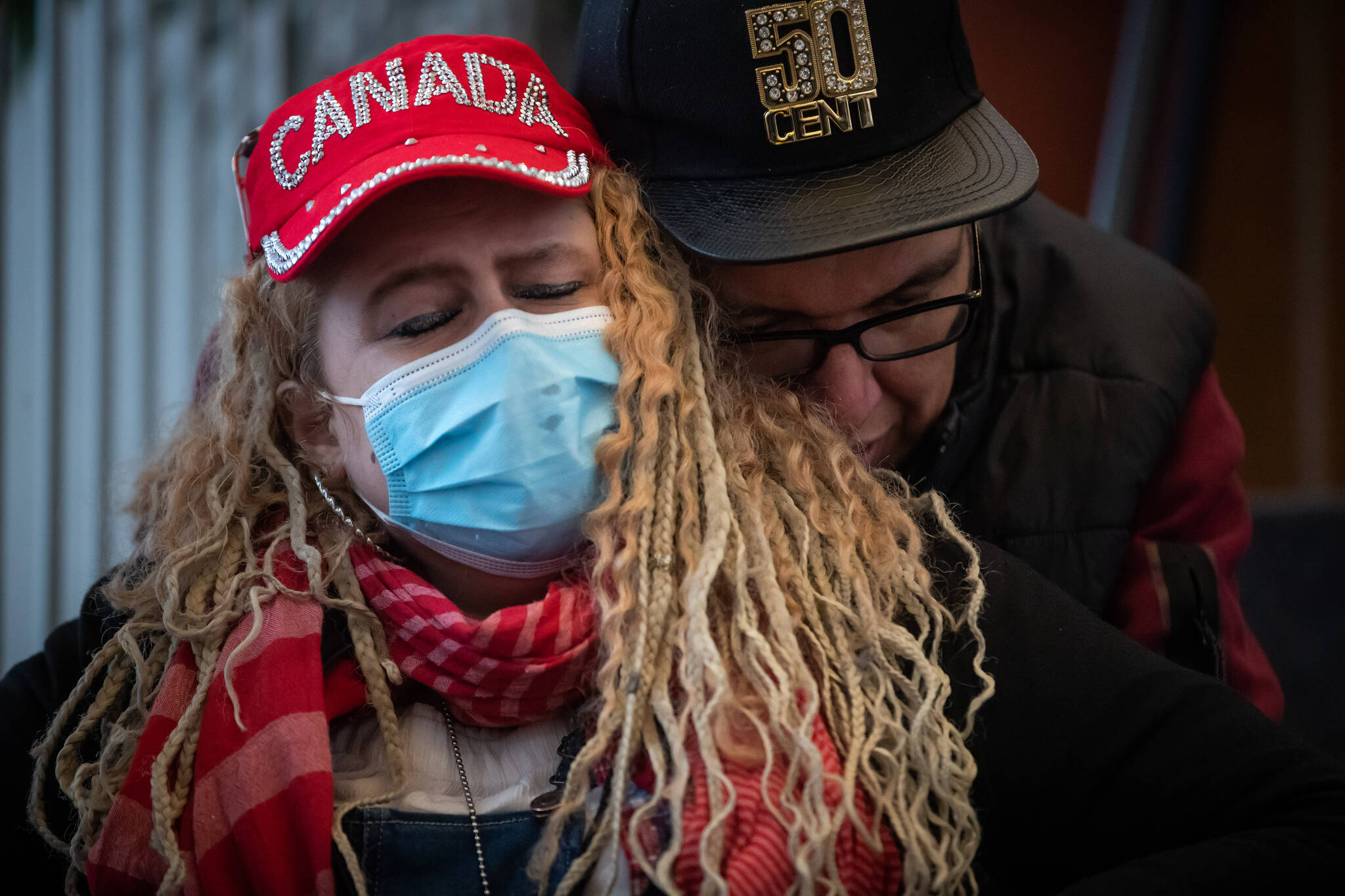 Curtis Traverse, right, comforts his girlfriend Hope as they listen to speeches in memory of those who died from a suspected illicit drug overdose, in Vancouver, on Wednesday, February 9, 2022. The B.C. Coroners Service announced that 2,224 people died from a suspected illicit drug overdose in 2021. The Drug User Liberation Front (DULF), Vancouver Area Network of Drug Users (VANDU) and B.C. Association of People on Opiate Maintenance distributed a tested supply of illicit drugs to users after the gathering in a call for a safer drug supply. THE CANADIAN PRESS/Darryl Dyck