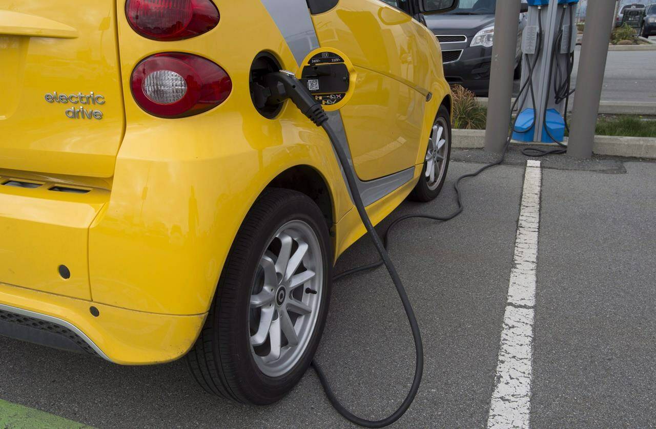 An electric car is seen getting charged at parking lot in Tsawwassen, near Vancouver B.C., Friday, April, 6, 2018. The Canadian auto industry says federal budget programs for electric vehicles and charging stations aren’t enough to reach the government’s ambitious new sales targets.THE CANADIAN PRESS/Jonathan Hayward