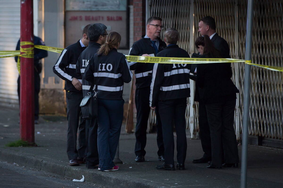 FILE – Members of the Independent Investigations Office of BC (IIO) talk at the scene where a Vancouver Police officer shot and killed a man who allegedly stabbed three people in the Downtown Eastside of Vancouver, B.C., on Thursday April 9, 2015. The IIO leads investigations into officer-related incidents of death or serious harm in British Columbia. THE CANADIAN PRESS/Darryl Dyck