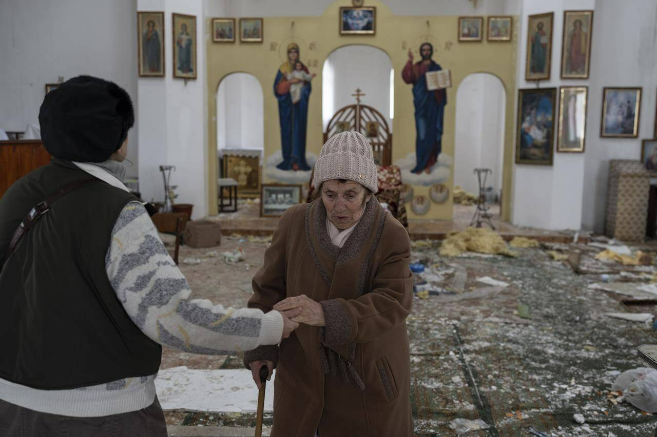 A woman reacts as she enters a damaged church following a Russian attack in the previous weeks in the town of Makarov , Kyiv region Ukraine, on Sunday, April 10, 2022. Since the beginning of the war at least 59 spiritual sites, most are Orthodox churches have been ruined or damaged, the Ukrainian authorities said. (AP Photo/Petros Giannakouris)