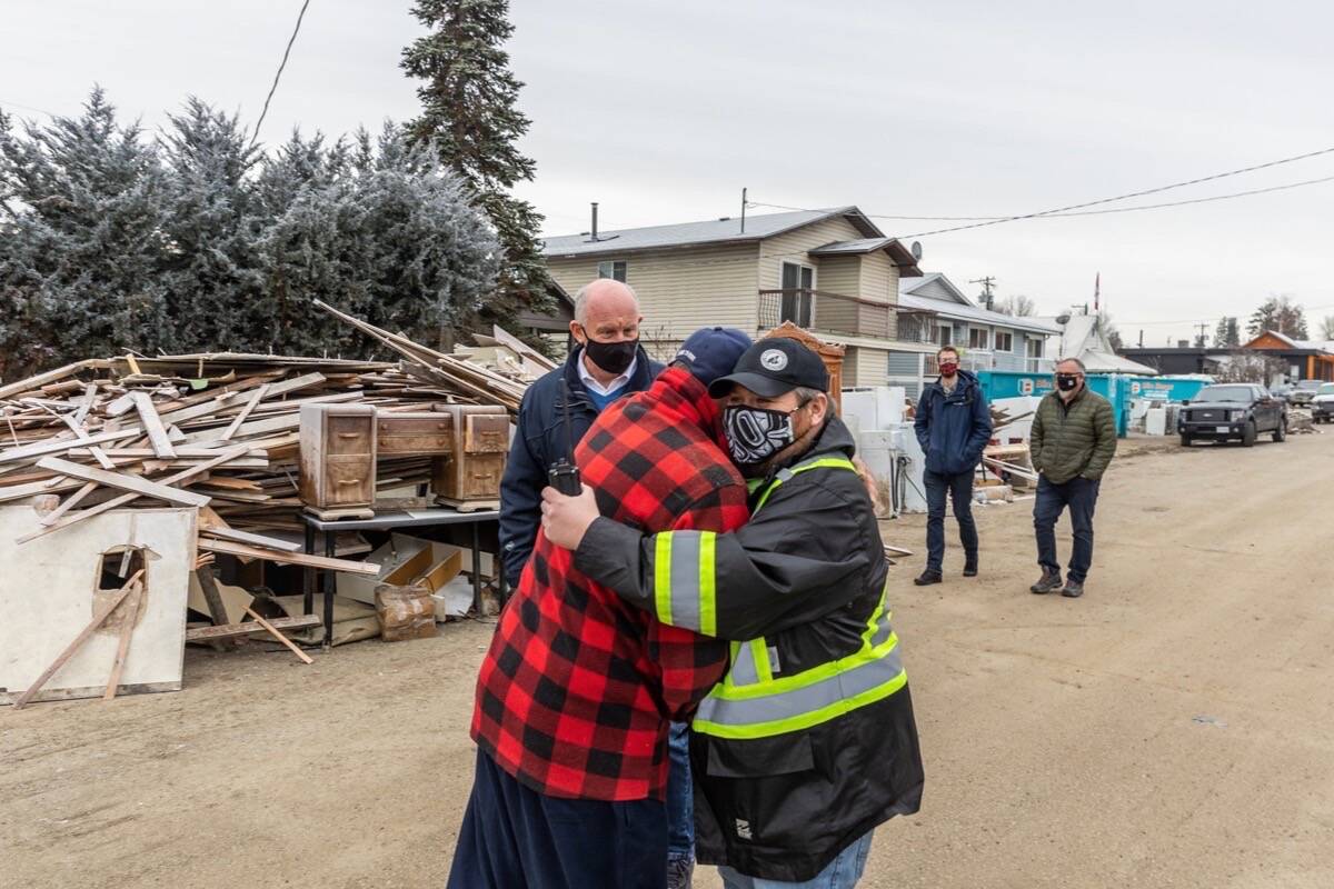 Princeton Mayor Spencer Coyne (reflective vest) consoles a resident as he and Public Safety Minister Mike Farnworth tour the flood-damaged community, Dec. 3, 2021. (B.C. government photo)