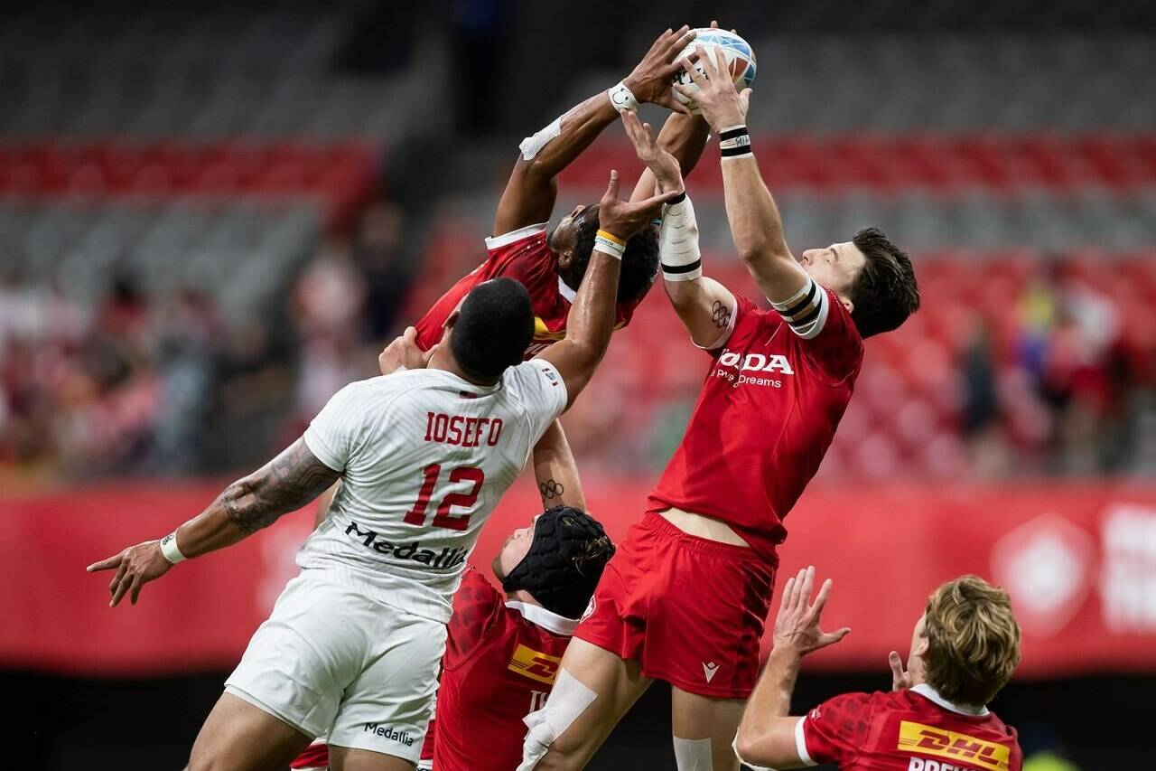 United States’ Martin Iosefo (12) vies for the ball against Canada’s Andrew Coe, right, and Josiah Morra, back, during HSBC Canada Sevens rugby action, in Vancouver, on September 18, 2021. THE CANADIAN PRESS/Darryl Dyck