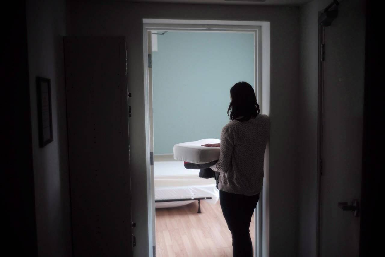 A staff member carries bedding in one of the suites at Toronto’s Interval House, an emergency shelter for women in abusive situations, on Monday February 6, 2017. THE CANADIAN PRESS/Chris Young