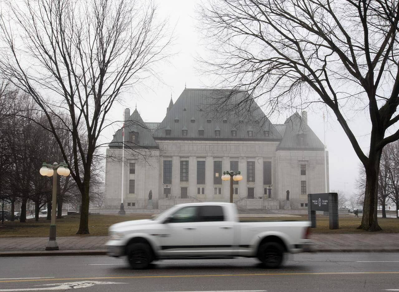 A pickup truck passes in front of the Supreme Court of Canada in Ottawa, Thursday, March 25, 2021. THE CANADIAN PRESS/Adrian Wyld