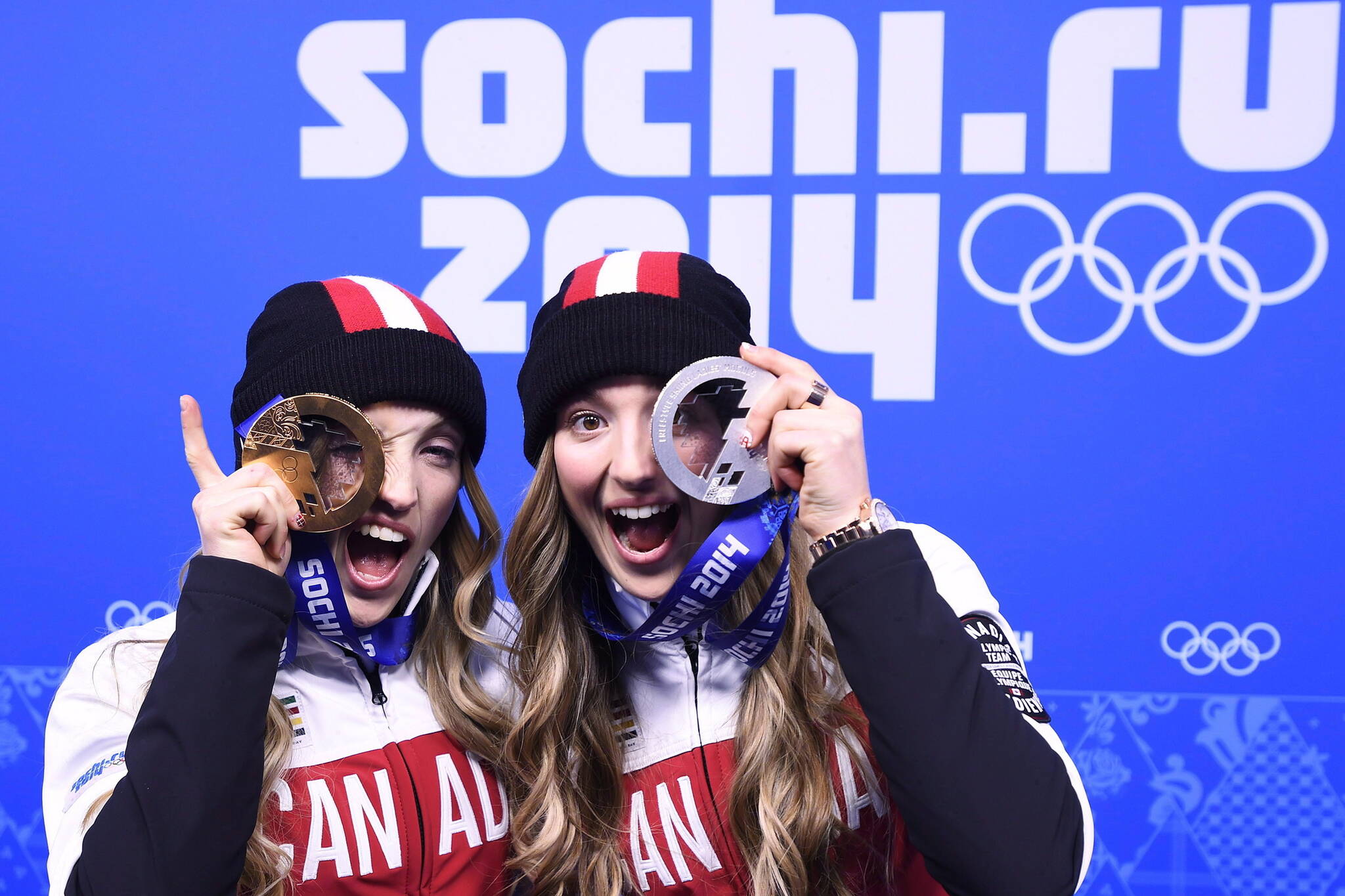 Canadian sisters Justine Dufour-Lapointe, left, and Chloe Dufour-Lapointe, right, show off their gold and silver medals from women’s freestyle moguls after the medal ceremony at the 2014 Sochi Winter Olympics in Sochi, Russia on Sunday, February 9, 2014.THE CANADIAN PRESS/Nathan Denette