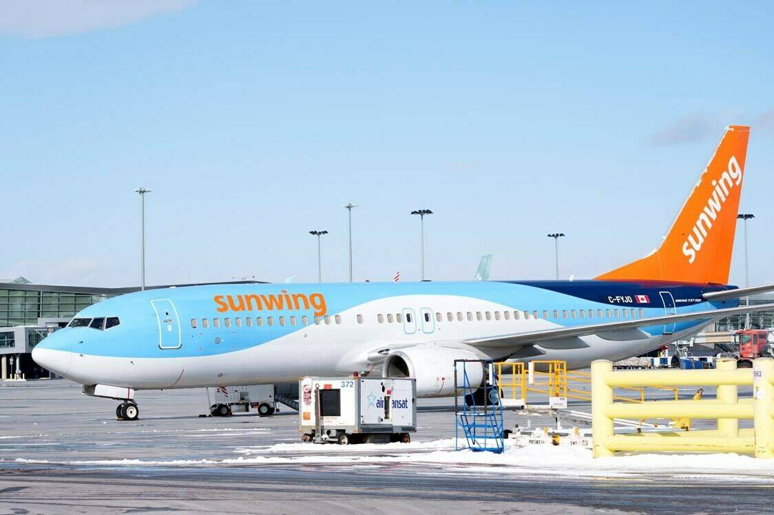 A Sunwing aircraft is parked at Montreal Trudeau airport in Montreal on Wednesday, March 2, 2022. Sunwing Airlines Inc. says thousands of passengers remain stranded and the start of vacations delayed as the company continues to struggle with a technical problem that has grounded flights. THE CANADIAN PRESS/Paul Chiasson