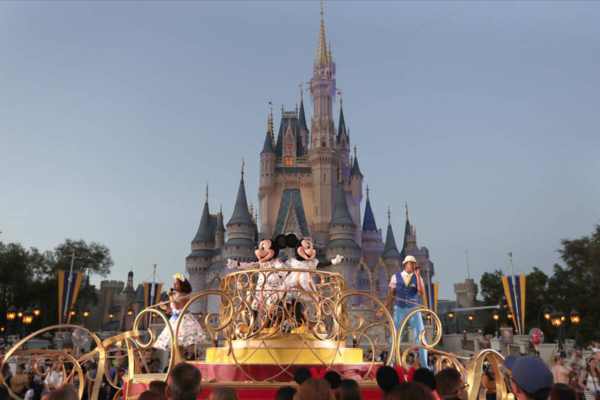 Mickey and Minnie Mouse perform during a parade as they pass by the Cinderella Castle at the Magic Kingdom theme park at Walt Disney World in Lake Buena Vista, Fla. The theme park resort announced Tuesday, Feb. 15, 2022, that face coverings will be optional for fully-vaccinated visitors in all indoor and outdoor locations, with one exception. Face masks still will be needed for visitors ages 2 and older on enclosed transportation, such as the resort’s monorail, buses and the resort’s sky gondola. (AP Photo/John Raoux, File)