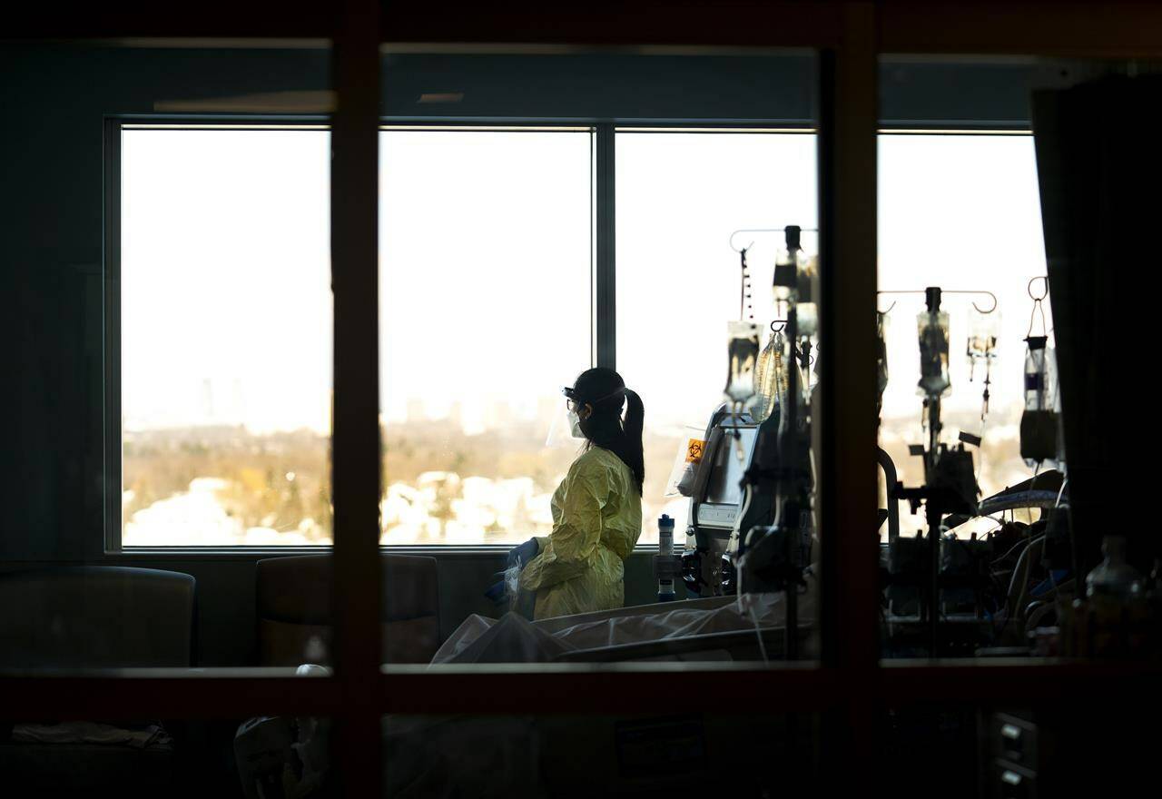 A registered nurse takes a moment to look outside while attending to a ventilated COVID-19 patient in the intensive care unit. THE CANADIAN PRESS/Nathan Denette