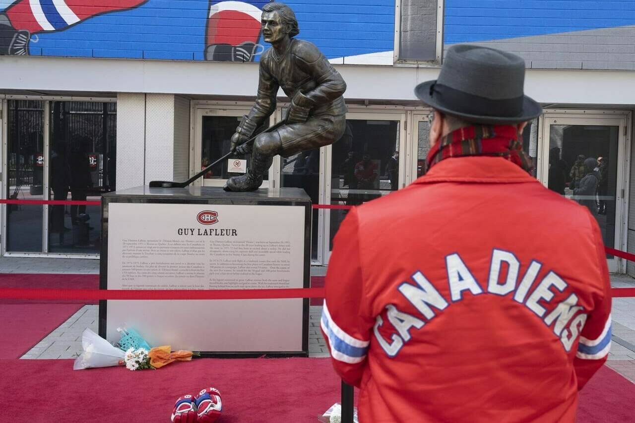 A fan pays his respects at a statue honouring Guy Lafleur in front of the Bell Centre in Montreal, on Friday, April 22, 2022. THE CANADIAN PRESS/Ryan Remiorz