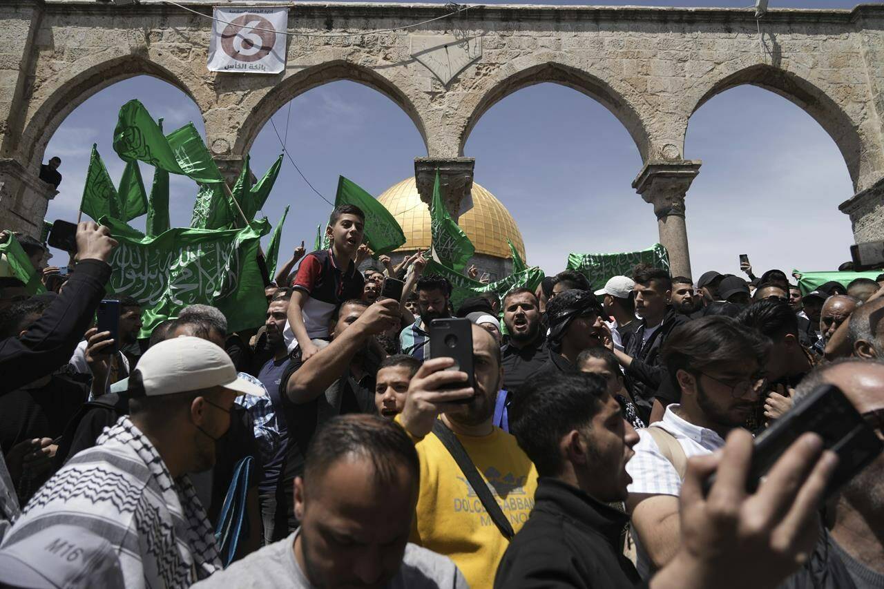 Palestinians chant slogans and wave Hamas flags after Friday prayers during the Muslim holy month of Ramadan, hours after Israeli police clashed with protesters at the Al Aqsa Mosque compound, in Jerusalem’s Old City, Friday, April 22, 2022. (AP Photo/Mahmoud Illean)