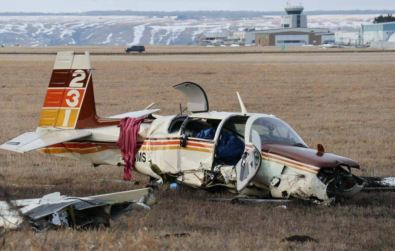 A small aircraft lies in a field next to the Trans-Canada Highway, within sight of the Springbank airport, after a fatal crash in Cochrane, west of Calgary, Alta., Friday, April 22, 2022. THE CANADIAN PRESS/Dave Chidley