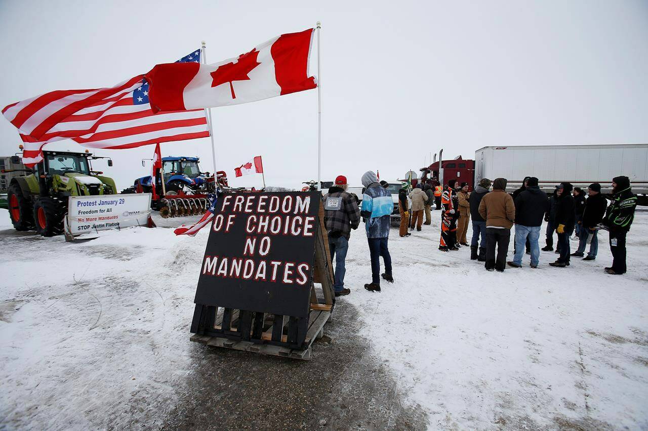 People block highway 75 with heavy trucks and farm equipment and access to the Canada/US border crossing at Emerson, Man., Thursday, Feb. 10, 2022. The federal government has until the end of the day today to call an inquiry into its use of the Emergencies Act during the blockades at Canadian border crossings and in Ottawa earlier this year. THE CANADIAN PRESS/John Woods