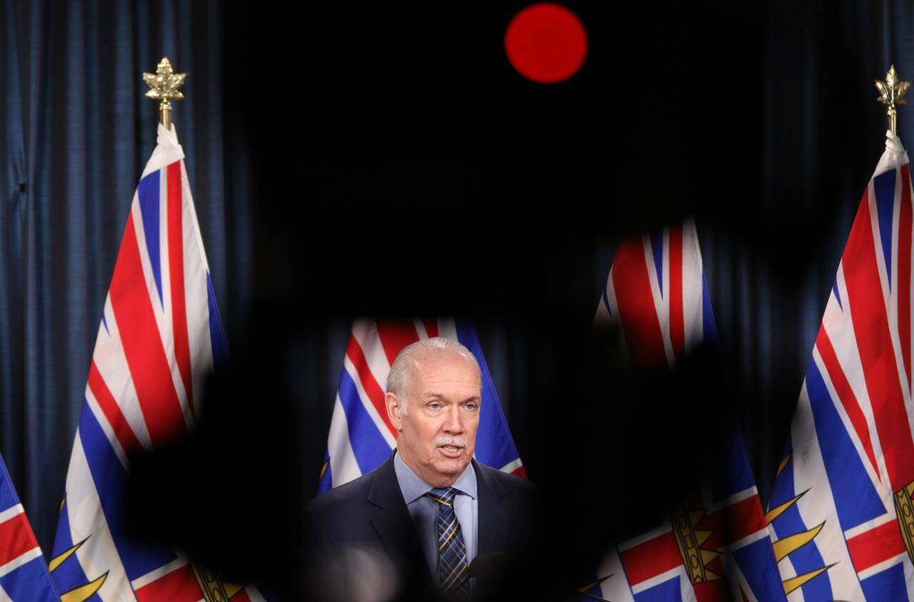 Premier John Horgan answers questions during a news conference in the press theatre at the legislature in Victoria, Friday, March 11, 2022. Politicians and media members met each other face-to-face at the British Columbia legislature after more than two years of COVID-19 protocols that had limited interactions. THE CANADIAN PRESS/Chad Hipolito