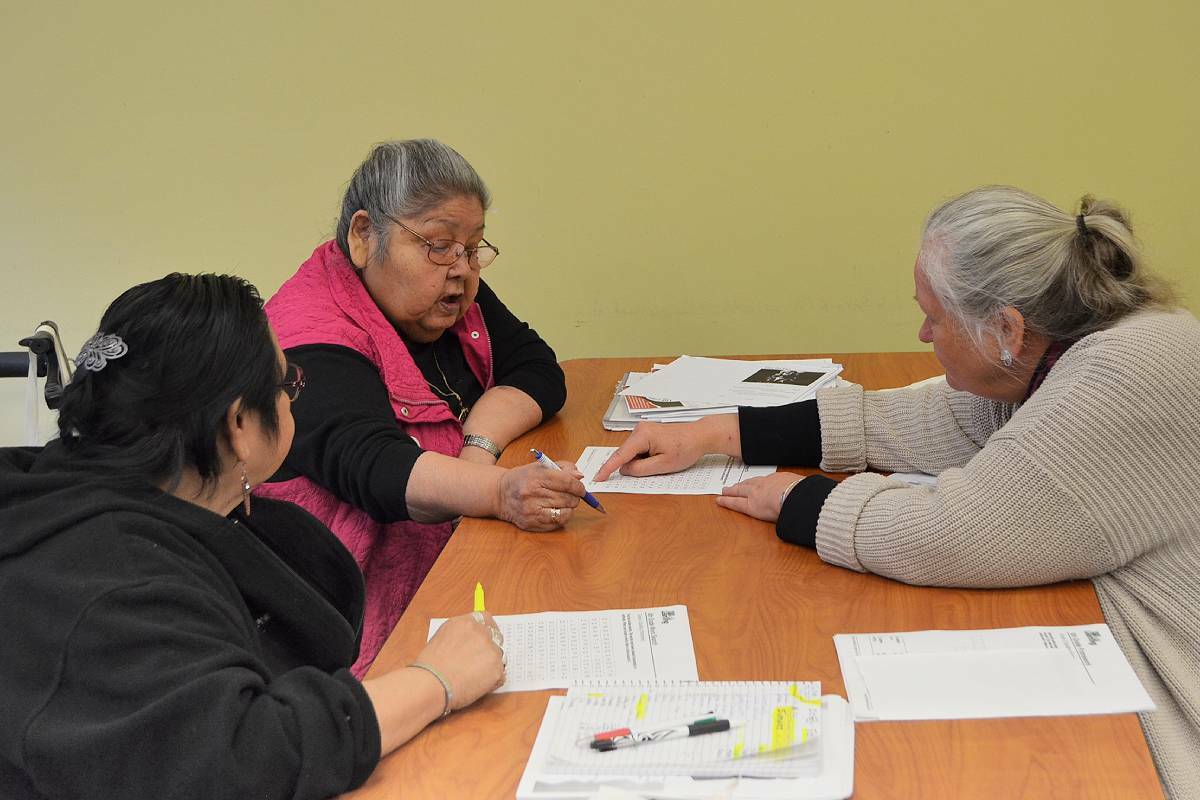 Students Joanne Bob, left, and Yvonne Frenchie receive help with classroom exercises from FEATHERS Society literary program instructor Maureen Robinson on Wednesday, April 20, at the Vancouver Island Conference Centre. (Mandy Moraes/News Bulletin)