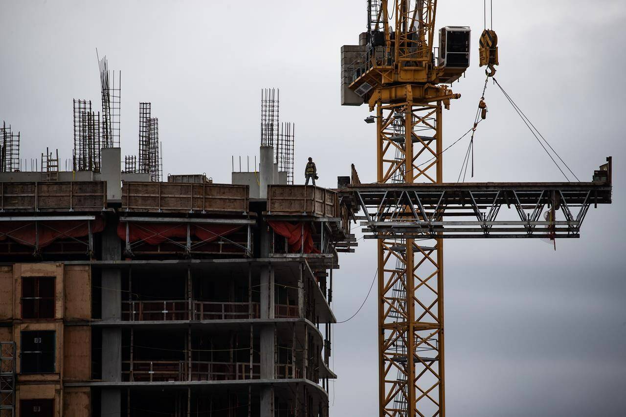 A tradesperson stands atop a condo tower under construction, in Burnaby, B.C., on Wednesday, March 2, 2022. THE CANADIAN PRESS/Darryl Dyck