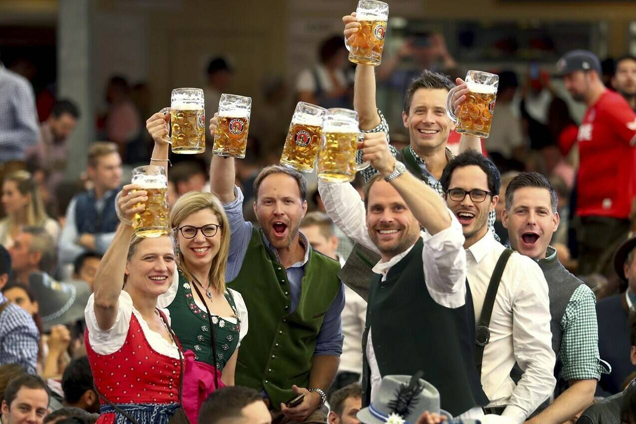 FILE - In this Saturday, Sept. 21, 2019 file photo, visitors lift glasses of beer during the opening of the 186th 'Oktoberfest' beer festival in Munich, Germany. The city of Munich said Friday that the annual Oktoberfest will take place again this fall, after a two-year pause due to the coronavirus pandemic (AP Photo/Matthias Schrader, file)