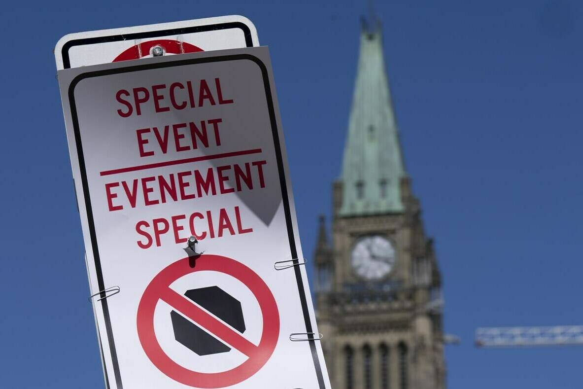 A temporary no-stopping sign is fixed with paper clips to a road sign near Parliament Hill, Thursday, April 28, 2022 in Ottawa. The area is part of a motorized vehicle exclusion zone set by the Ottawa Police Service. THE CANADIAN PRESS/Adrian Wyld