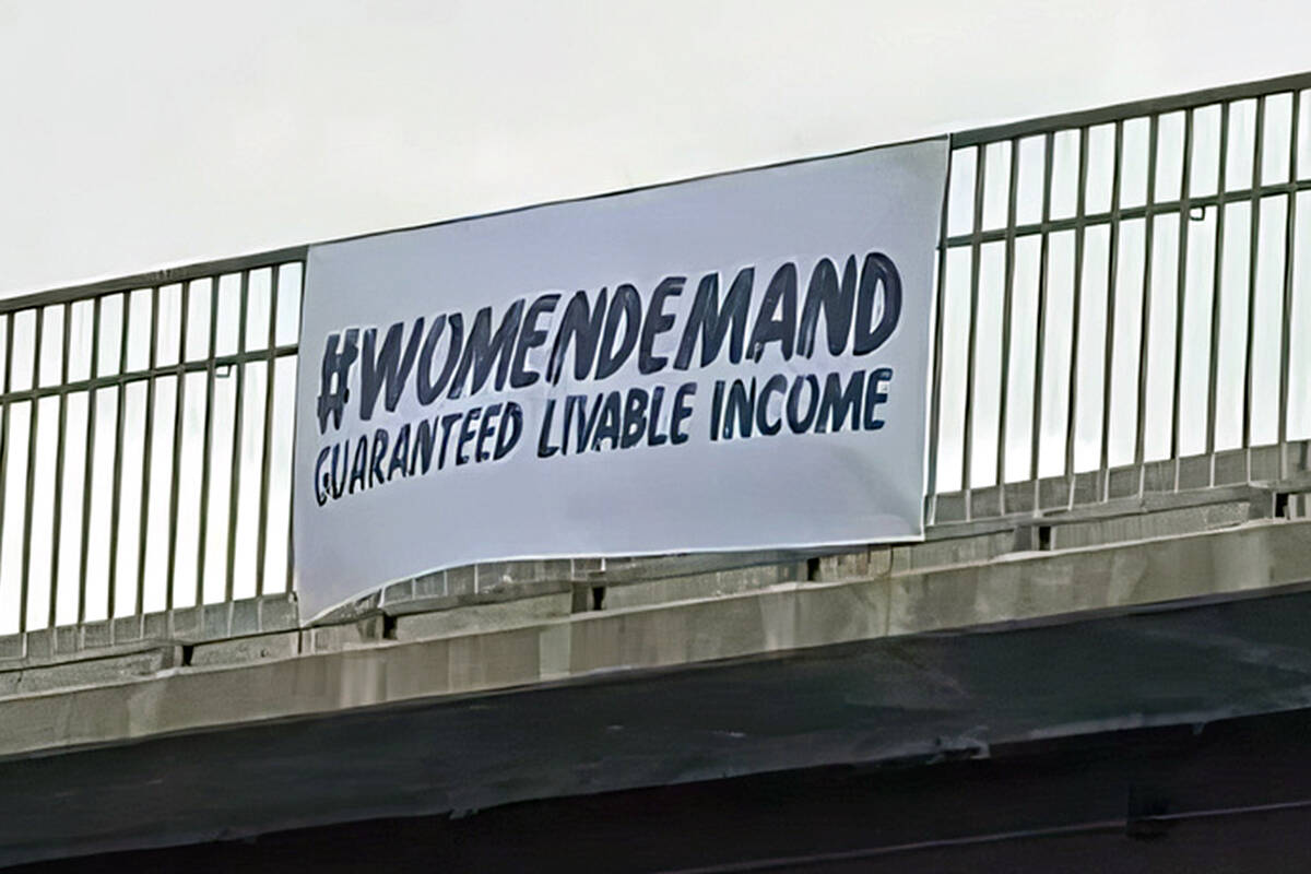 A banner calling for a ‘guaranteed livable income’ went up on the 196th Street overpass in Langley on Sunday, May 1, as part of a province-wide campaign. (Special to Langley Advance Times)